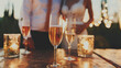 Glasses of champagne in the foreground. Wedding at sunset, blurred background
