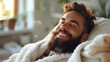 Relaxed bearded man lying on a sofa in a bathrobe. Home comfort and leisure concept for interior design and lifestyle