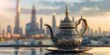 A gold colored teapot sits on a table in front of a city skyline