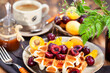 Fresh homemade belgian waffles decorated with cherry, apricot and salted caramel