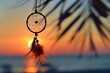 Dreamcatcher with beads and feathers on a beach at sunset, native american indian charm, hope and healing symbol