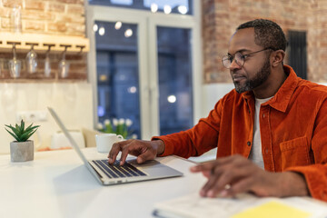 Wall Mural - Dark-skinned man in red shirt working and looking involved