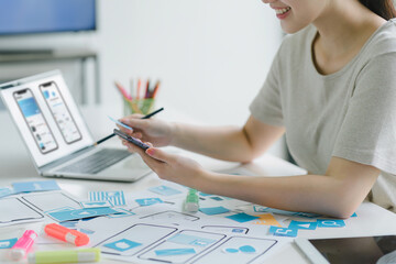 Wall Mural - creative ux ui designers team developing wireframe and sketching layout design mockup on smartphone 