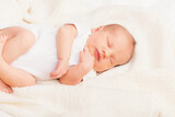 Fototapeta  - Newborn Baby Asleep on Cream Blanket