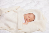 Fototapeta Londyn - Newborn Baby Asleep Wrapped in Knit Blanket