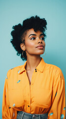 Wall Mural - beautiful african american woman in yellow shirt, isolated on blue