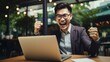 © Alex - Excited Asian Businessman Celebrating Success or Deal Agreement at Desk Generative AI