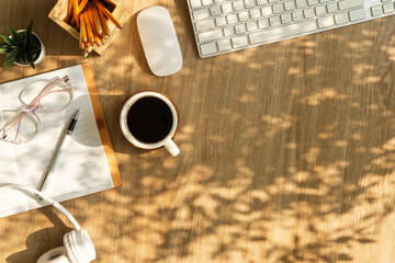 Wall Mural - A cup of coffee, notebook, glasses and headphone on wooden table. Top view with copy space.
