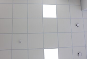 Wall Mural - White ceiling with PVC tiles and lighting indoors, bottom view