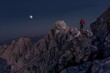climber reaching summit with moon overhead, visible trail