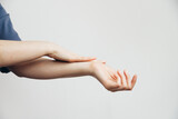 Fototapeta Konie - Beautiful Woman Applying Cosmetics on Hands, Lotion. Spa and Manicure concept, plain background