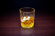 Whisky with ice on a wooden table