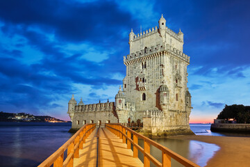 Wall Mural - Belem Tower or Tower of St Vincent - famous tourist landmark of Lisboa and tourism attraction - on the bank of the Tagus River (Tejo) after sunset in dusk twilight with dramatic sky. Lisbon, Portugal