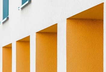 Entrances in the building and two windows above in yellow tones