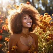 Portrait Of A Beautiful Young Woman With Curly Hair Smiling In A Field Of Yellow Flowers
