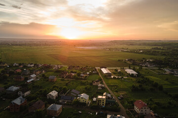 Wall Mural - Aerial view of residential houses in suburban rural area at sunset