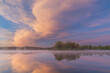 Foggy spring landscape at dawn of the shoreline of Whitford Lake with mirrored reflections in calm water, Fort Custer State Park, Michigan, USA