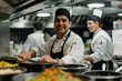 Smiling chef with two cooks preparing food in a restaurant kitchen

