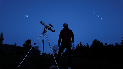 Wall Mural - amateur astronomer looking at the evening skies, observing planets, stars, moon and other celestial 