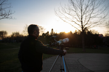 Wall Mural - amateur astronomer observing sun eclipse and sun with a telescope and special solar filter.
