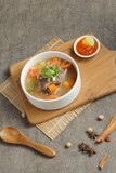 Fototapeta Na sufit - Bowl of meat soup on a wooden table