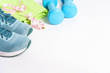 Wall Mural - Sneakers, dumbbells, green apple and bottle of water isolated on white background.