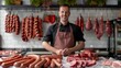 Salesman in butchery stands in a shop for meat and sausage