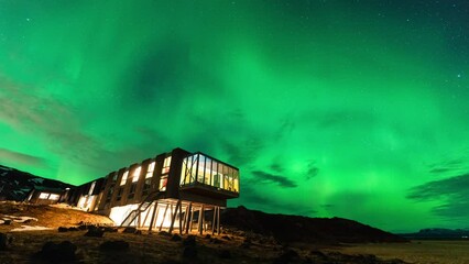 Wall Mural - aurora borealis, northern lights glowing over luxury hotel on mount hengill in winter at iceland