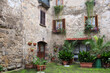 Piazzetta nel borgo di Montefiascone con abitazione in pietra vasi e piante