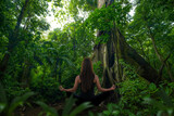 Fototapeta Krajobraz - Woman doing yoga in front of rainforest