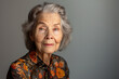 portrait of smiling senior lady on a solid gray background