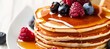 Delicious homemade american pancakes with fresh berries, honey, and copy space on white background
