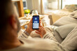 © Davor - Man checking bank account on smartphone at home