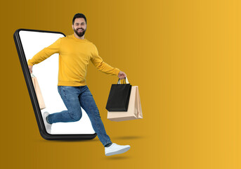 Sticker - Online shopping. Happy man with paper bags jumping out from smartphone on orange background, space for text