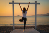 Fototapeta Tulipany - Joga, młoda dziewczyna praktykuje asany na wakacjach nad morzem. Wschód słońca na greckiej wyspie Kos. Ćwiczenia rozciągające, sport na powietrzu. 