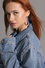 Sticker - Beautiful young woman in denim jacket on gray background