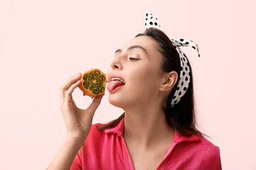 Sticker - Beautiful young woman with tasty kiwano on pink background