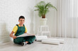 © Pixel-Shot - Little architect with house plan sitting in room