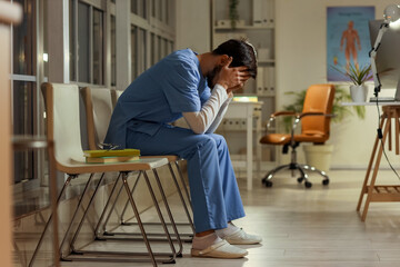 Sticker - Tired male nurse sitting at hospital in evening