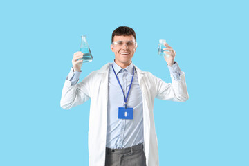 Canvas Print - Male chemist with flasks on blue background