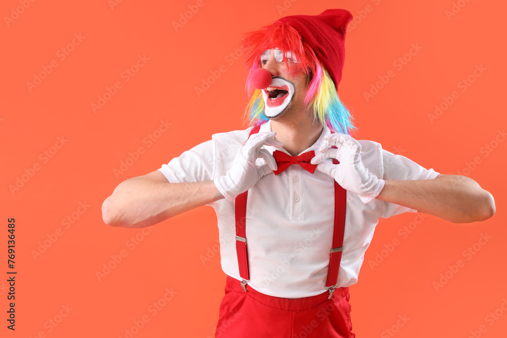 Portrait of happy clown with bow tie on orange background. April Fool's day celebration
