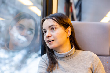 Caucasian woman looking through train window while journeying.