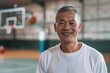 Smiling portrait of a senior man in indoor basketball gym