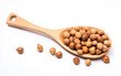 Brown hazelnuts on a wooden spoon isolated on white background. Close up view