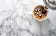 Fresh black coffee pouring into white mug on marble tabletop