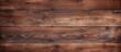 A detailed closeup of a brown hardwood plank table with a grainy texture, showcasing the natural beauty of the wood grain and varnish finish