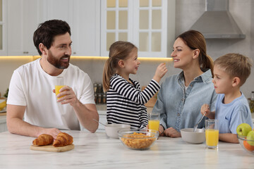 Canvas Print - Happy family having breakfast at table in kitchen