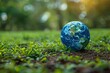 © LifeMedia - Earth represented as a globe laying on a natural green surface portrays a simple yet powerful connection to our planet