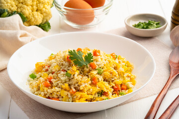 Cauliflower fried rice,Stir fried cauliflower rice with eggs ,carrot ,bean and corn in white plate.healthy eating and low calories food.low carb dish.