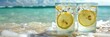 Relaxing beach day,where two glasses of freshly chilled lemonade sit amidst the sparkling waves and pristine sand The vibrant citrus slices and ice cubes